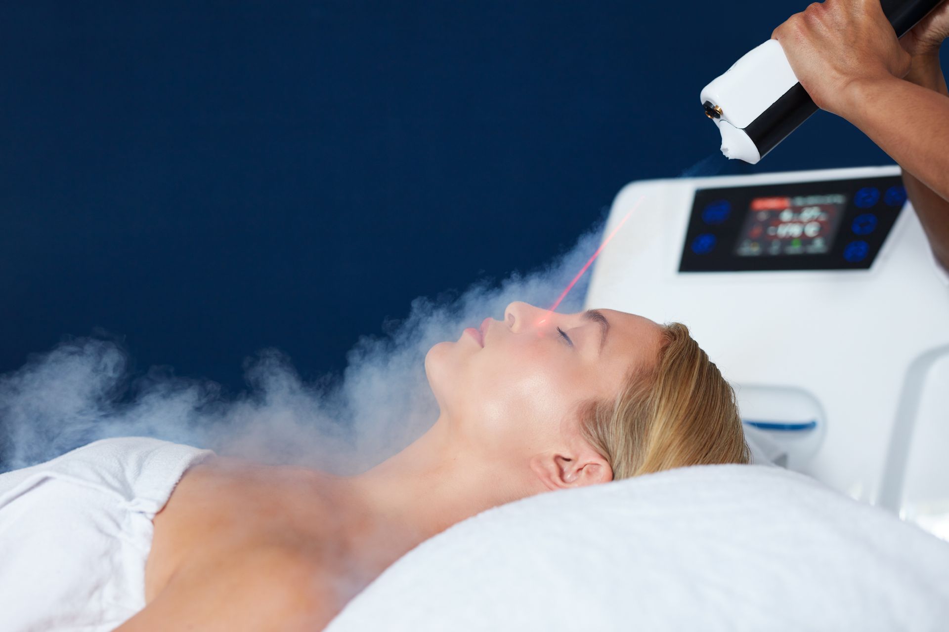 Small cryotherapy treatment room with cool light and warm espresso wood floor.